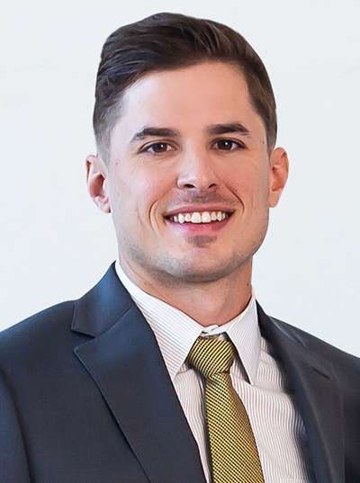 A man in a suit and tie is smiling for the camera.