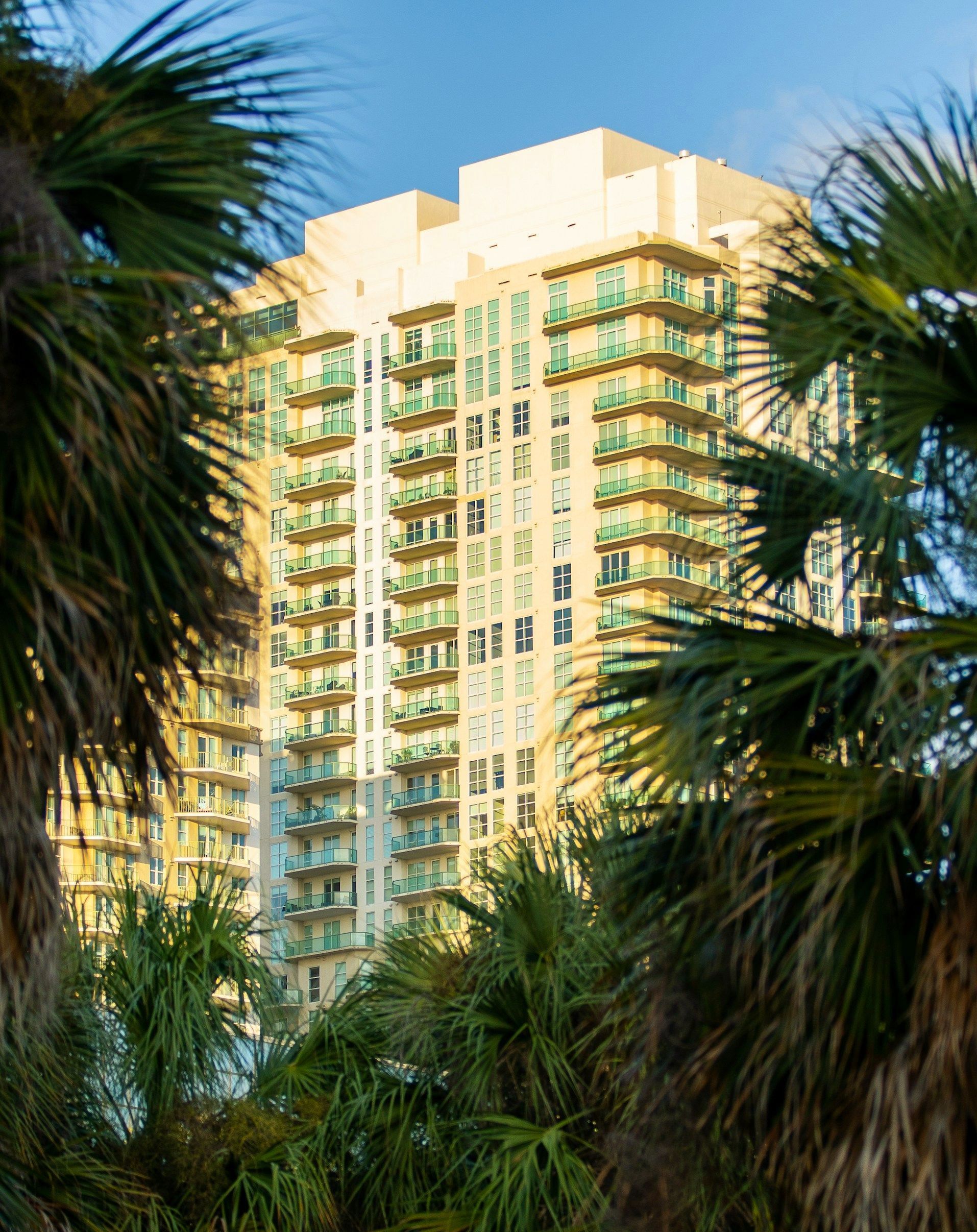 A tall building with palm trees in front of it