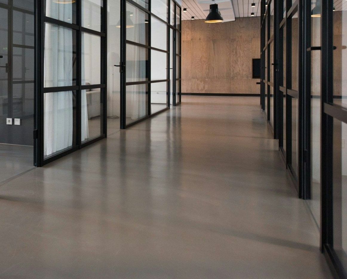 A long hallway with a lot of windows and a lamp hanging from the ceiling.