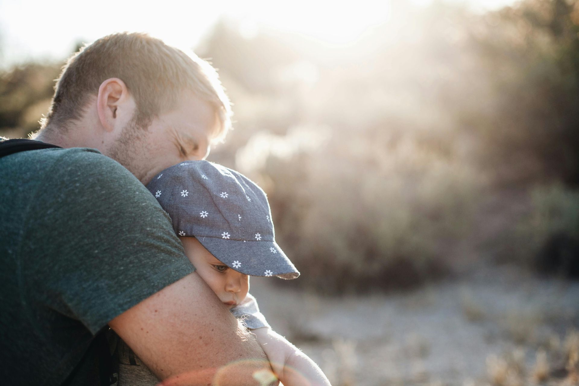 A man is holding a small child in his arms.