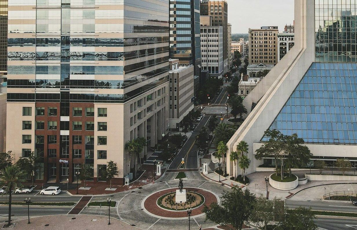 An aerial view of a city with a large building in the background.