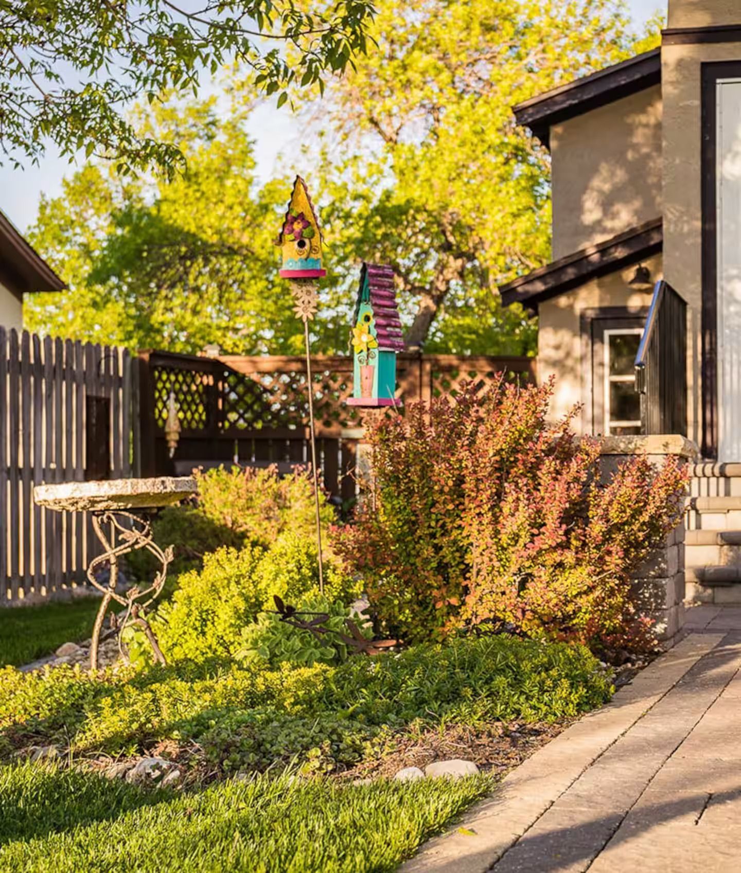 There is a birdhouse in the backyard of a house.