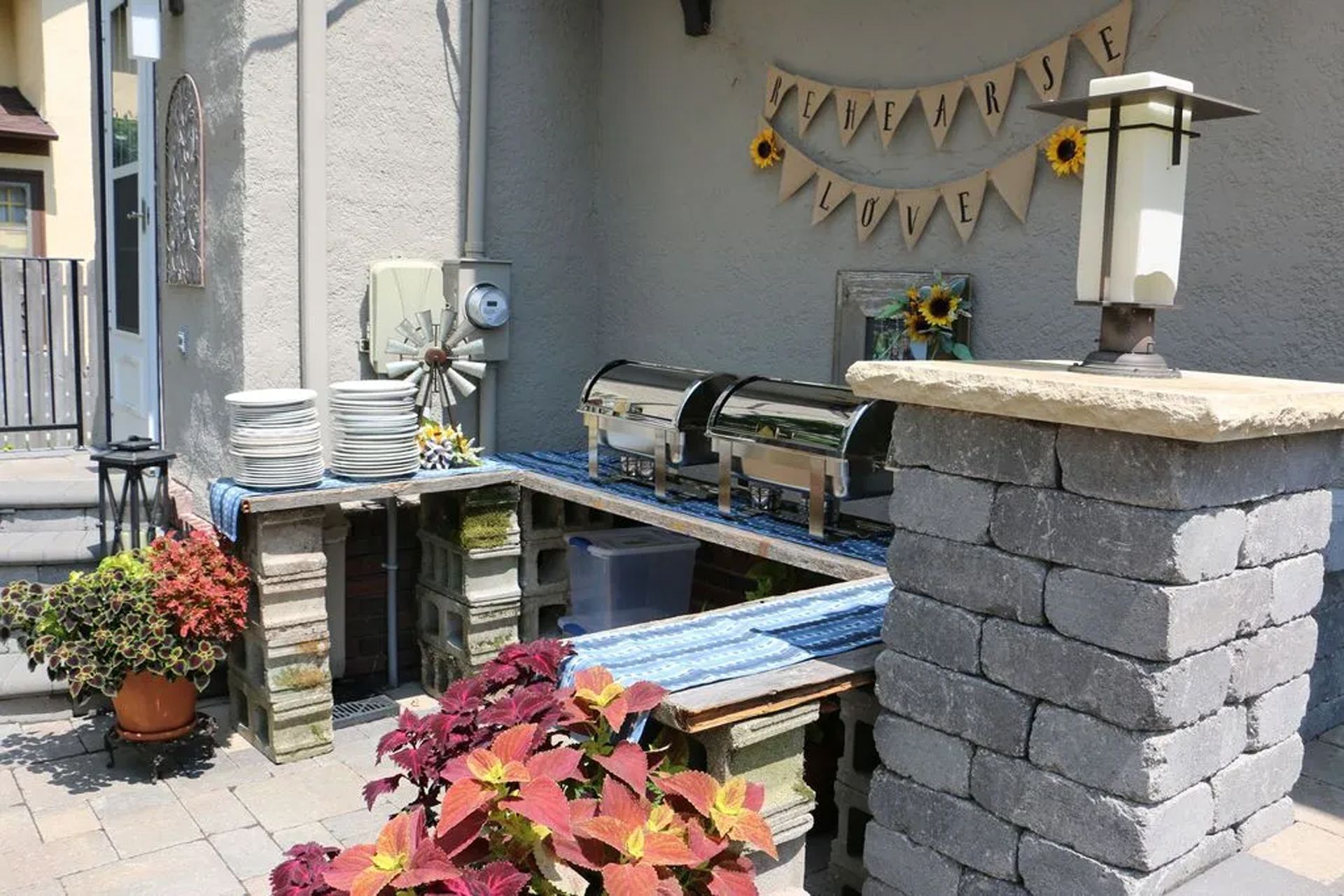 A patio with a buffet table and a brick pillar