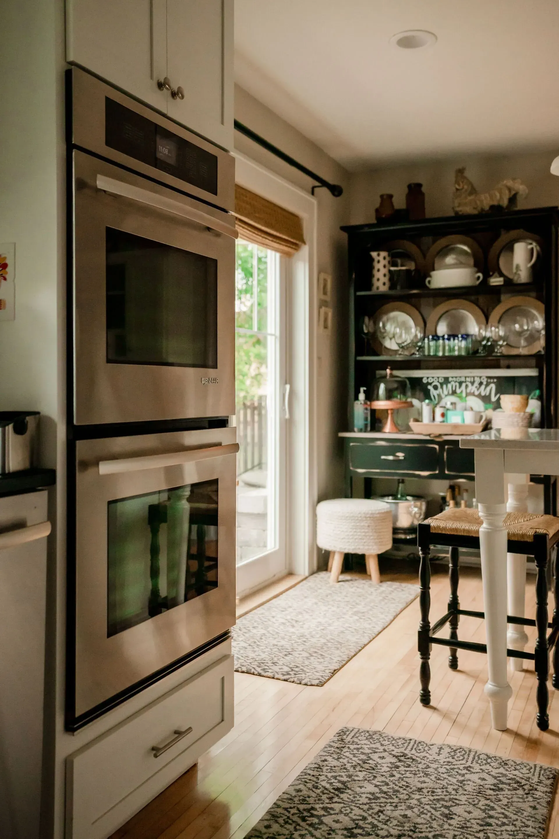 A kitchen with a stainless steel oven and a sliding glass door
