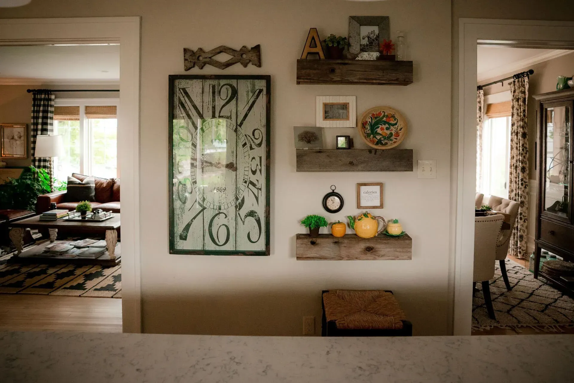 A living room with a clock on the wall and shelves