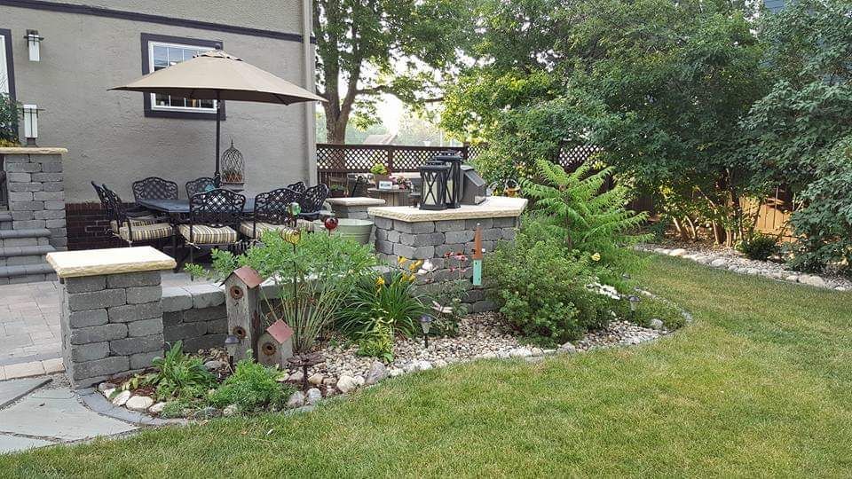 A backyard with a patio and umbrella and a house in the background