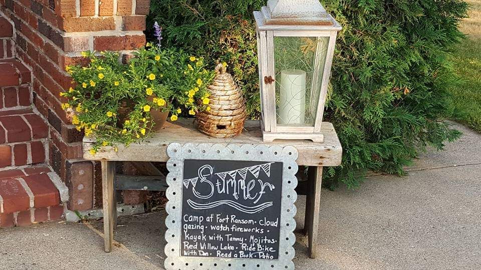 A chalkboard sign is sitting on a wooden