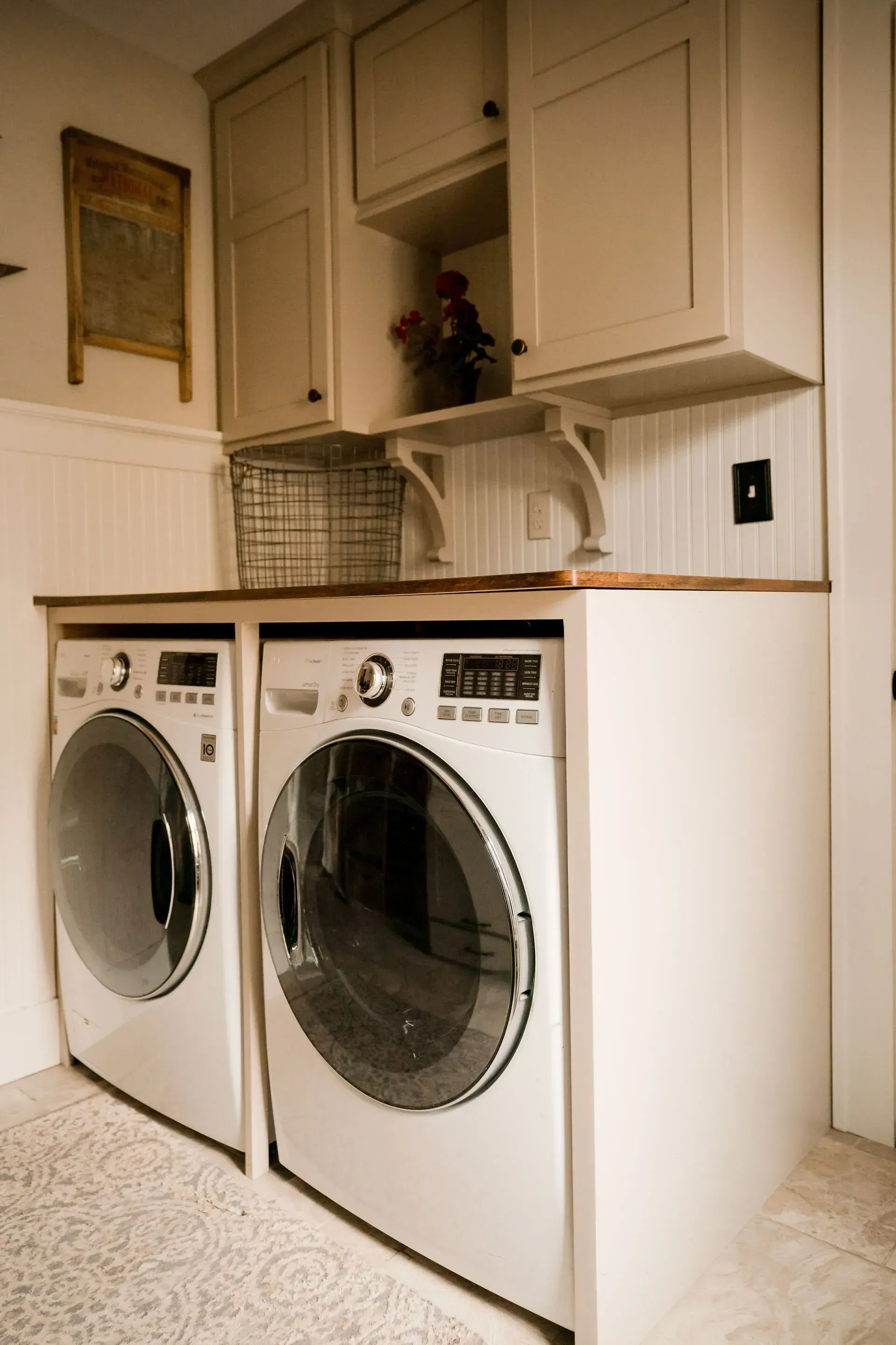 A laundry room with a washer and dryer on a counter