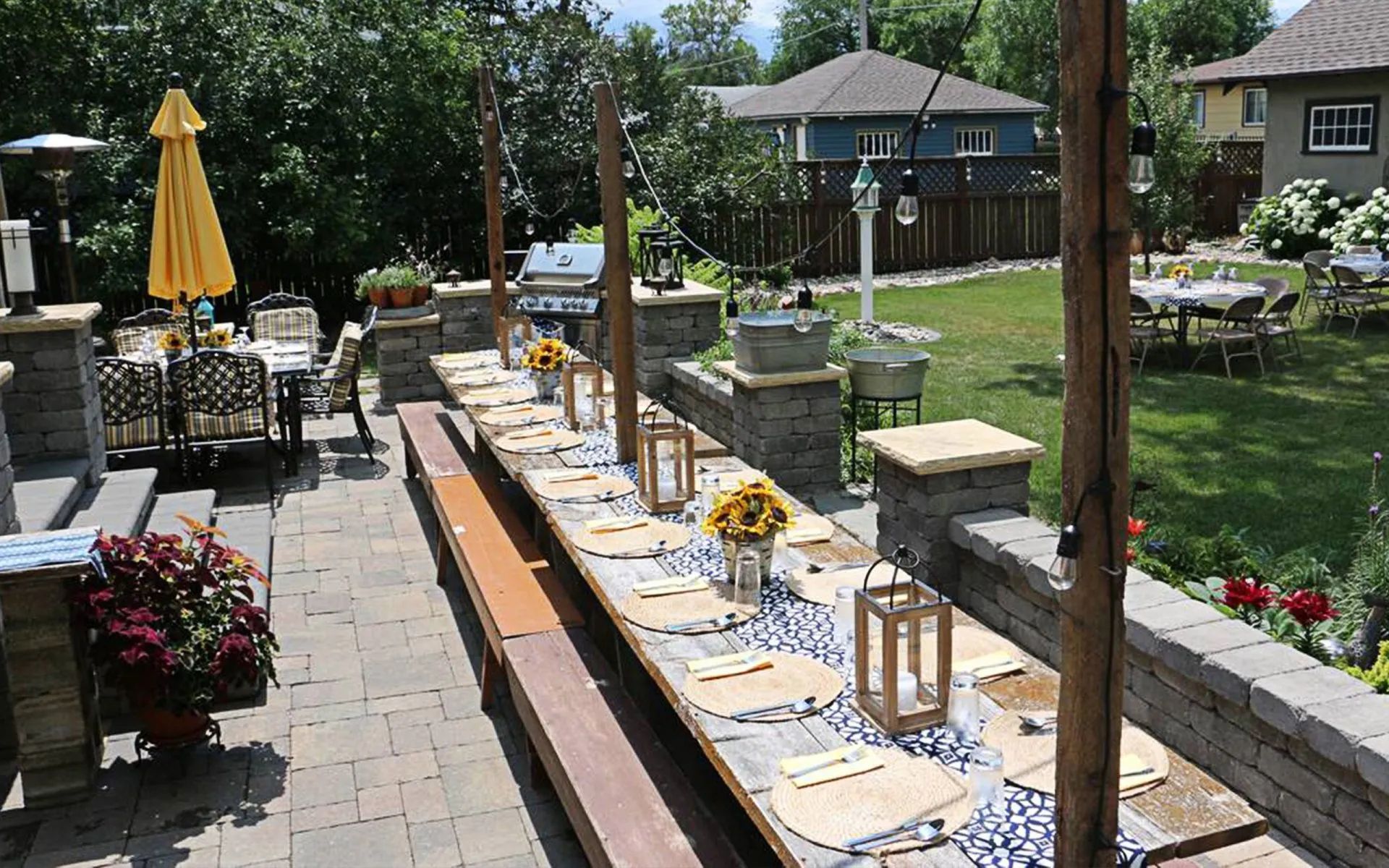 A long table is set for a party in a backyard