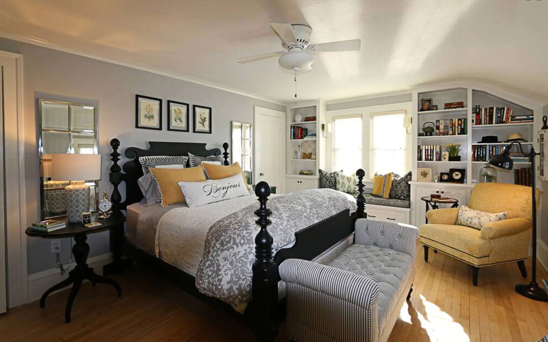 A bedroom with a large bed and a ceiling fan