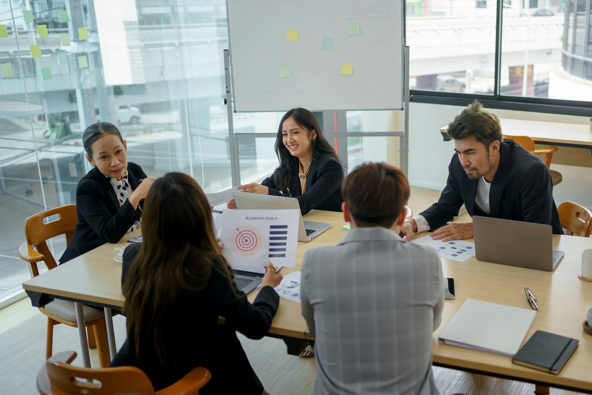 A group of people are sitting around a table having a meeting.