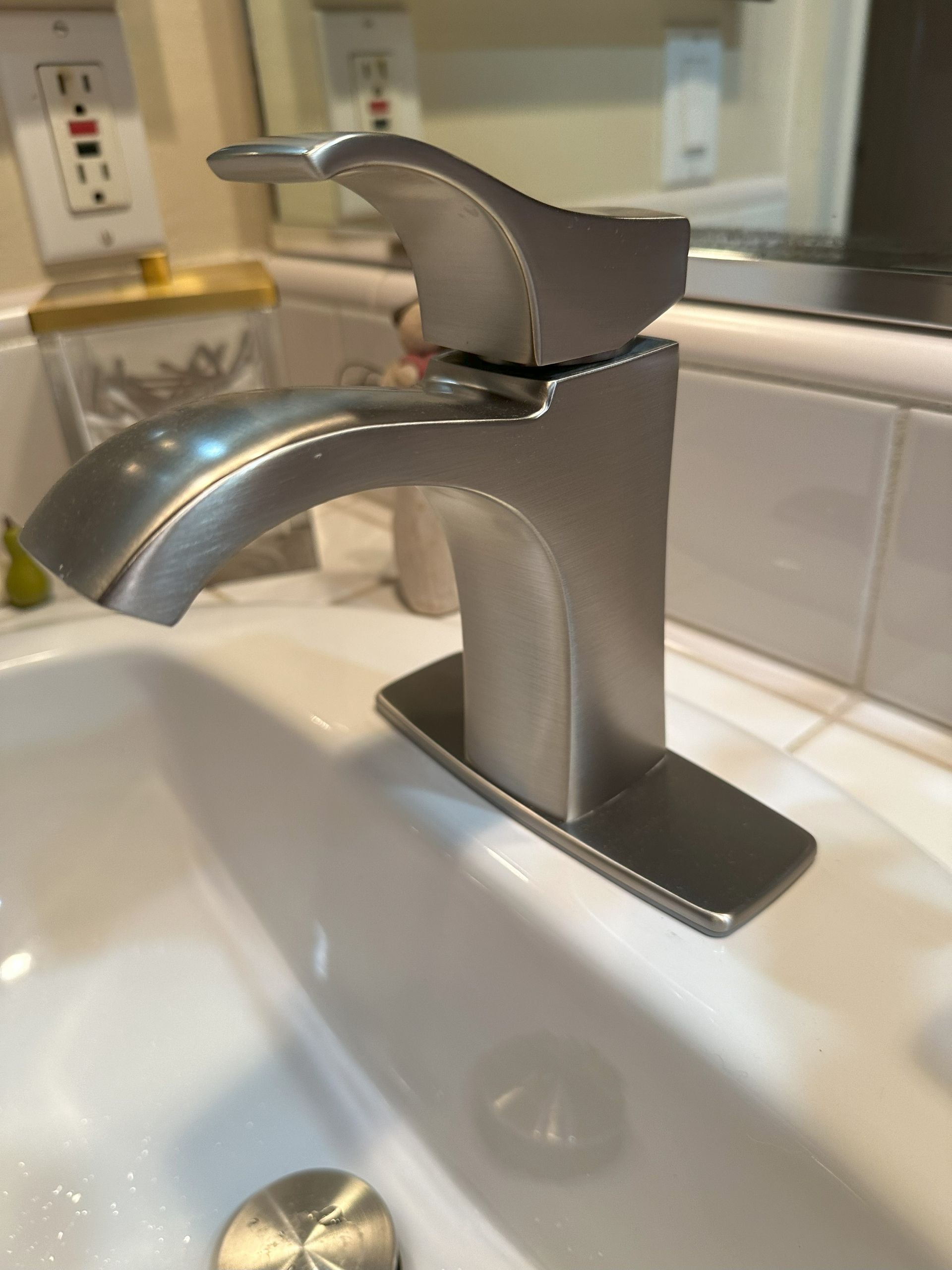 A bathroom sink with a silver faucet and a mirror.