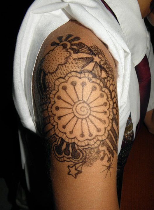 A person has a tattoo on their arm that looks like a flower