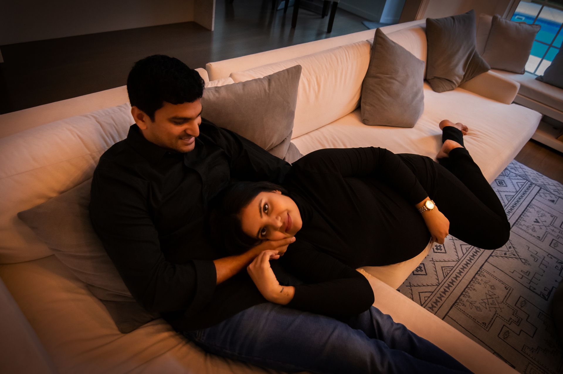 A man and a woman are laying on a couch.