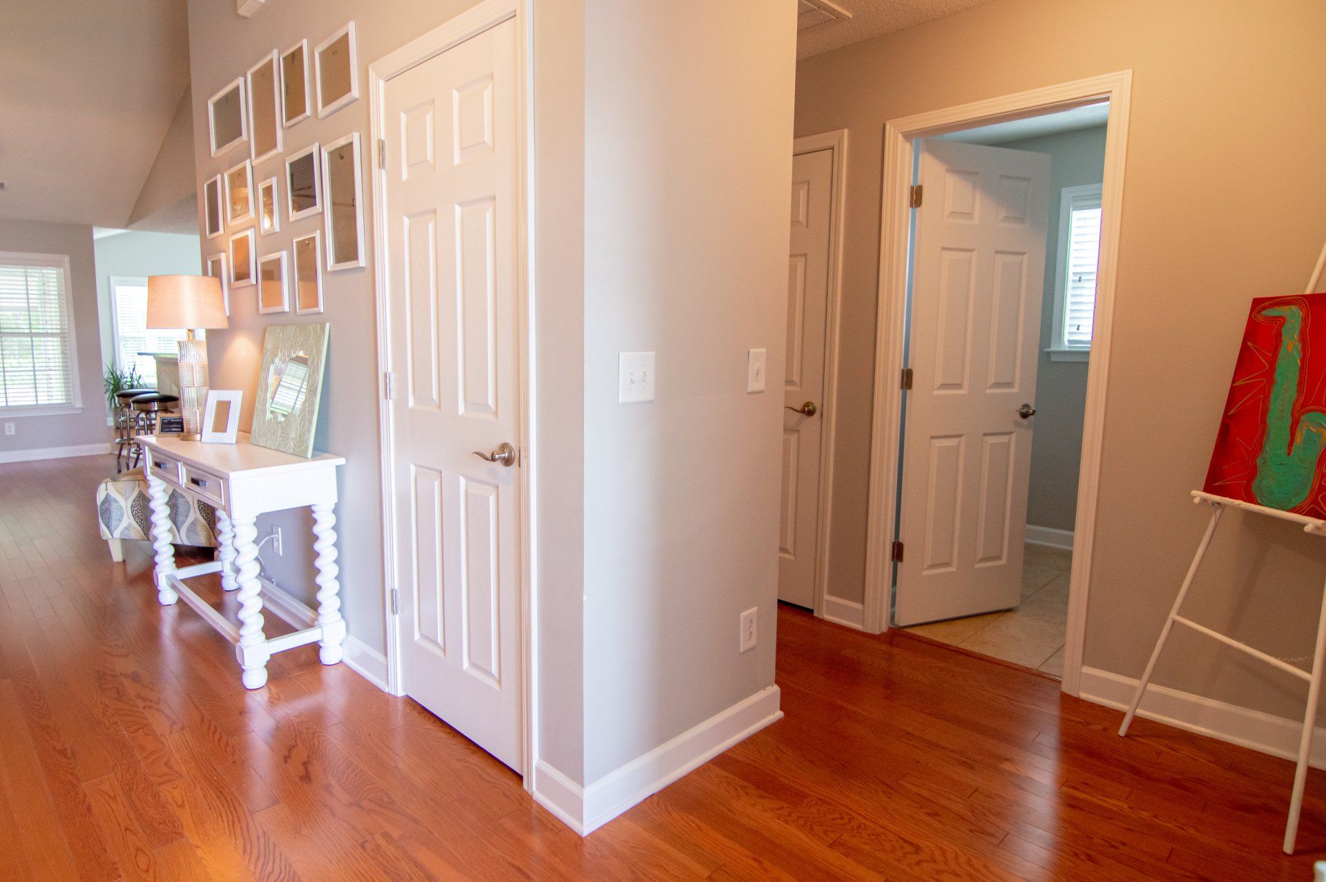 A hallway in a house with hardwood floors and white doors