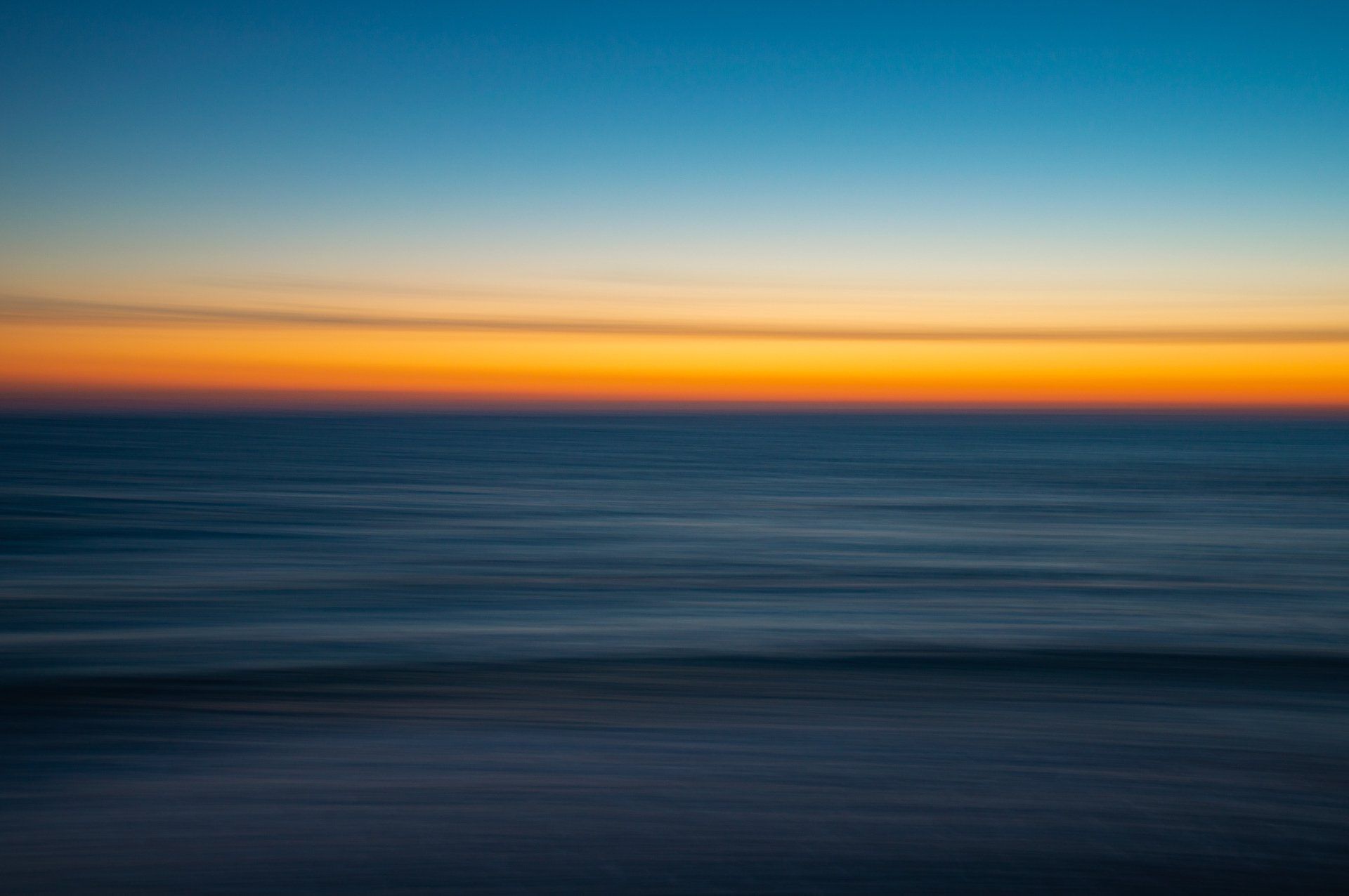 A blurry picture of a sunset over the ocean.