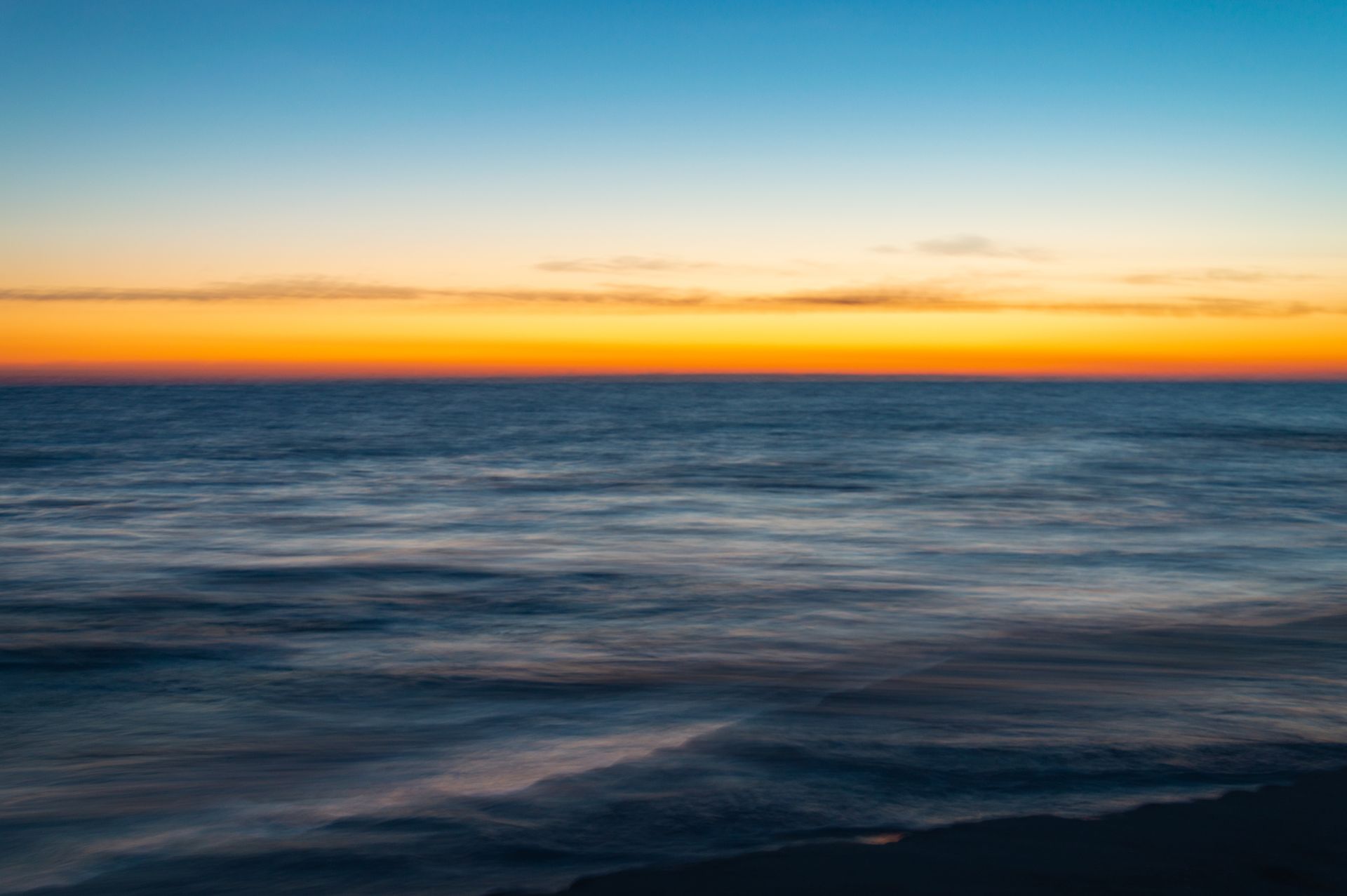 A blurry picture of a sunset over the ocean.