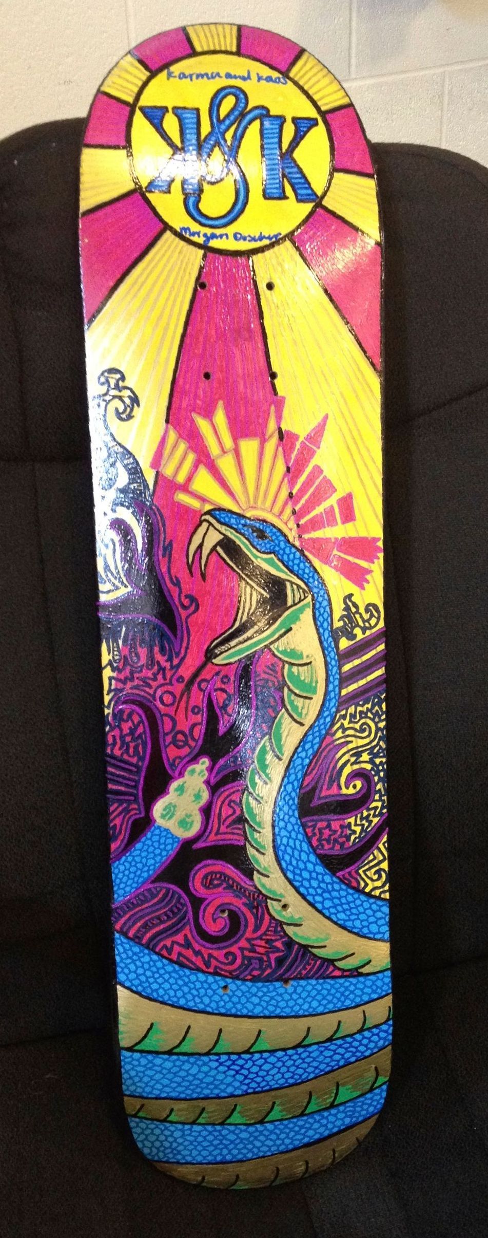 A colorful skateboard with a snake on it