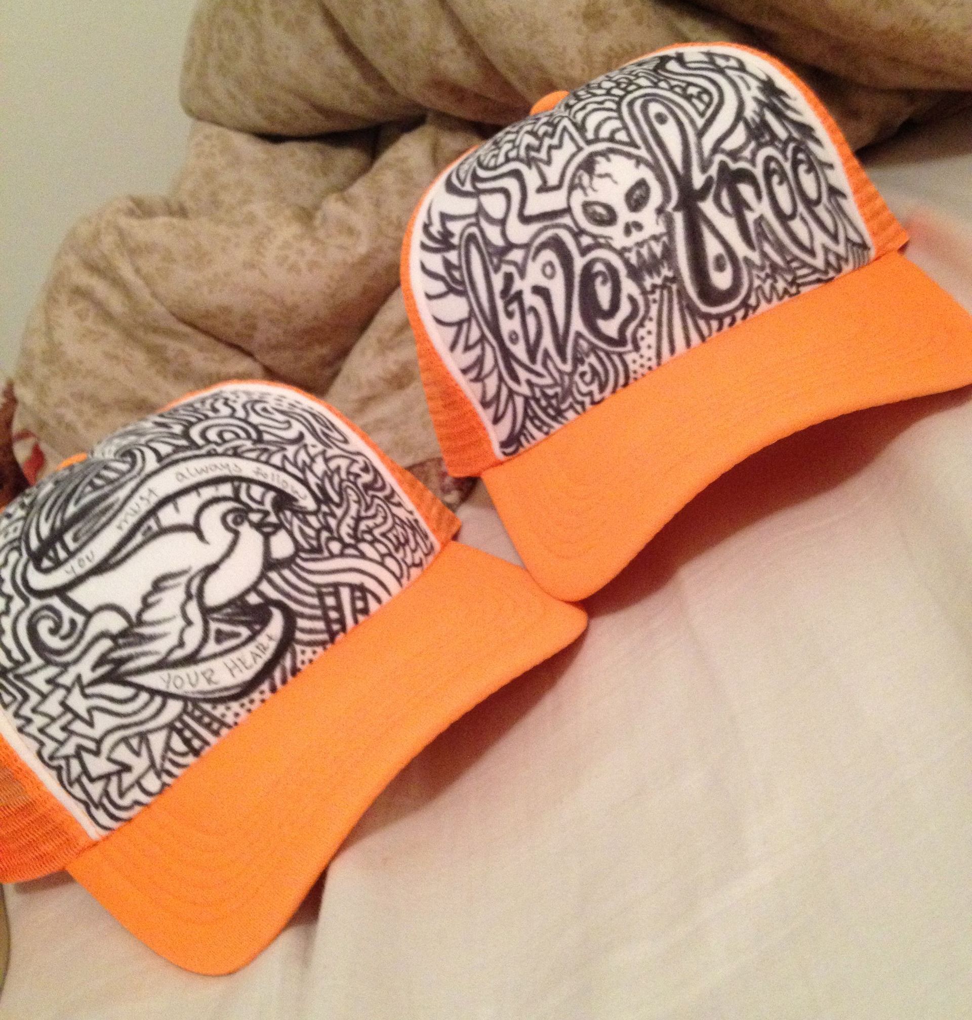 Two orange hats with the word love on them