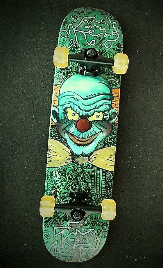 A green skateboard with a clown face on it