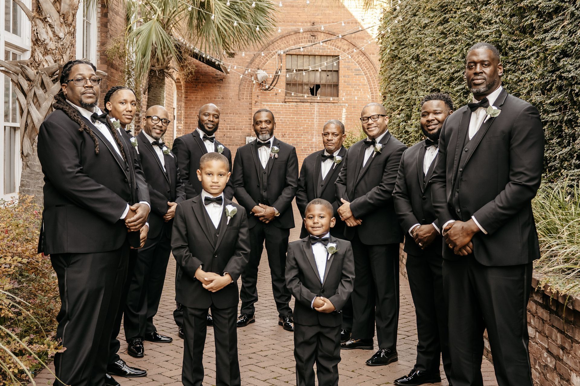 A group of men in tuxedos and bow ties are posing for a picture.