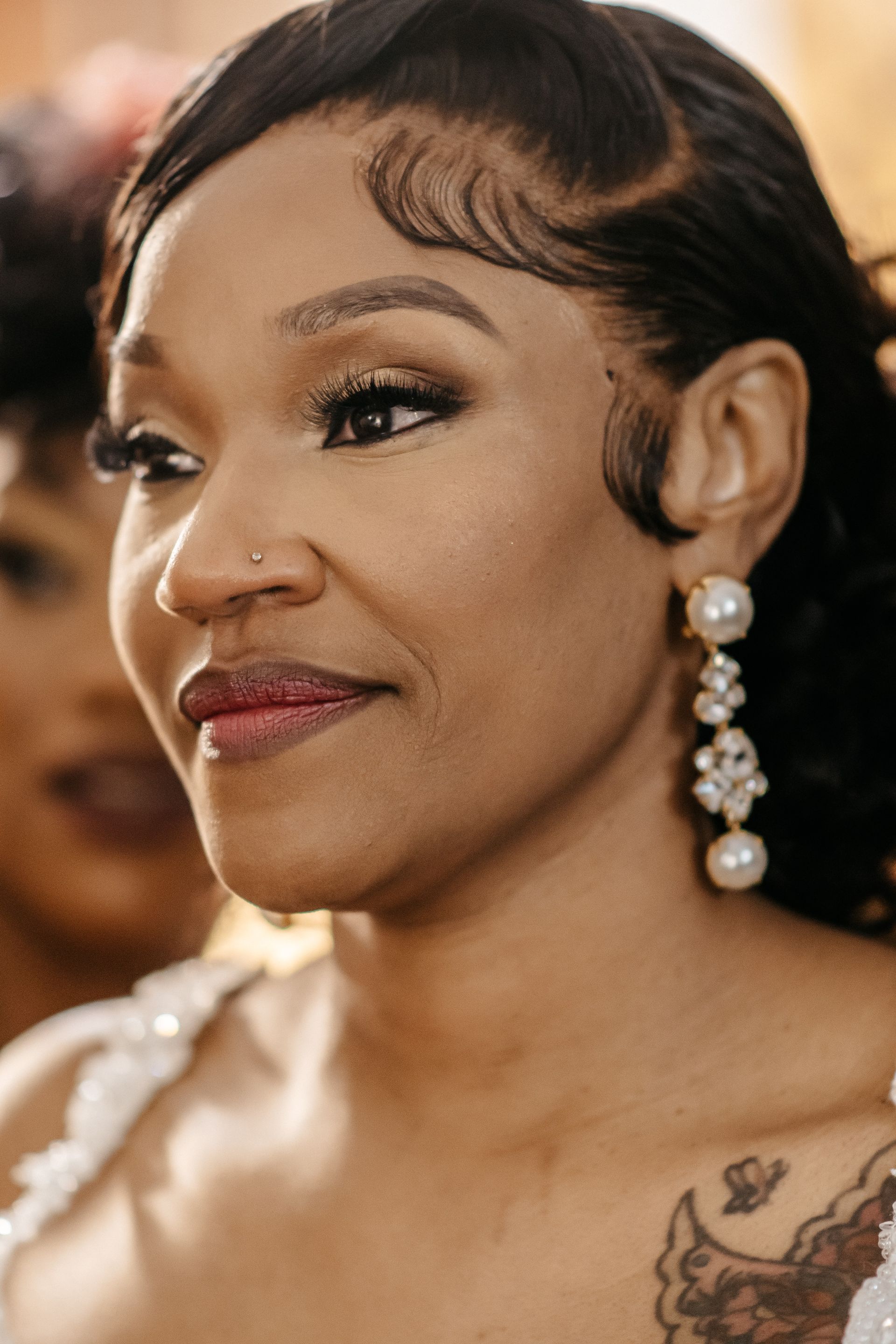 A close up of a woman wearing earrings and a nose ring.