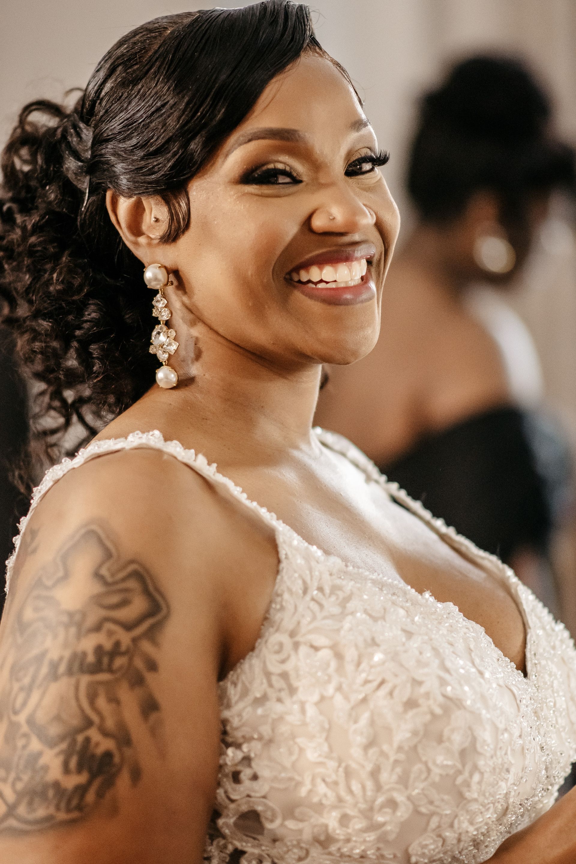 A woman in a wedding dress is smiling and looking at the camera.