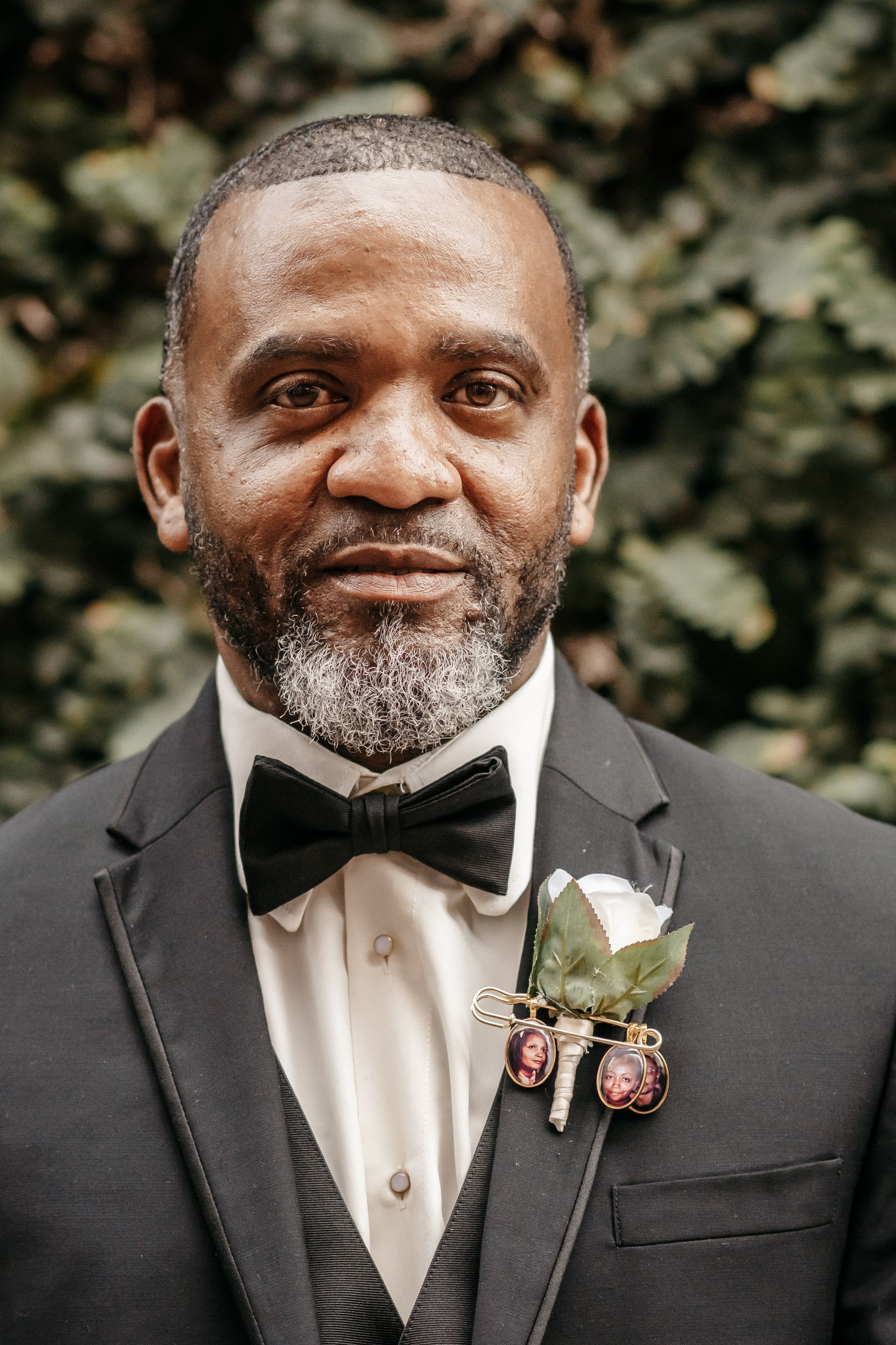 A man with a beard is wearing a suit and bow tie.