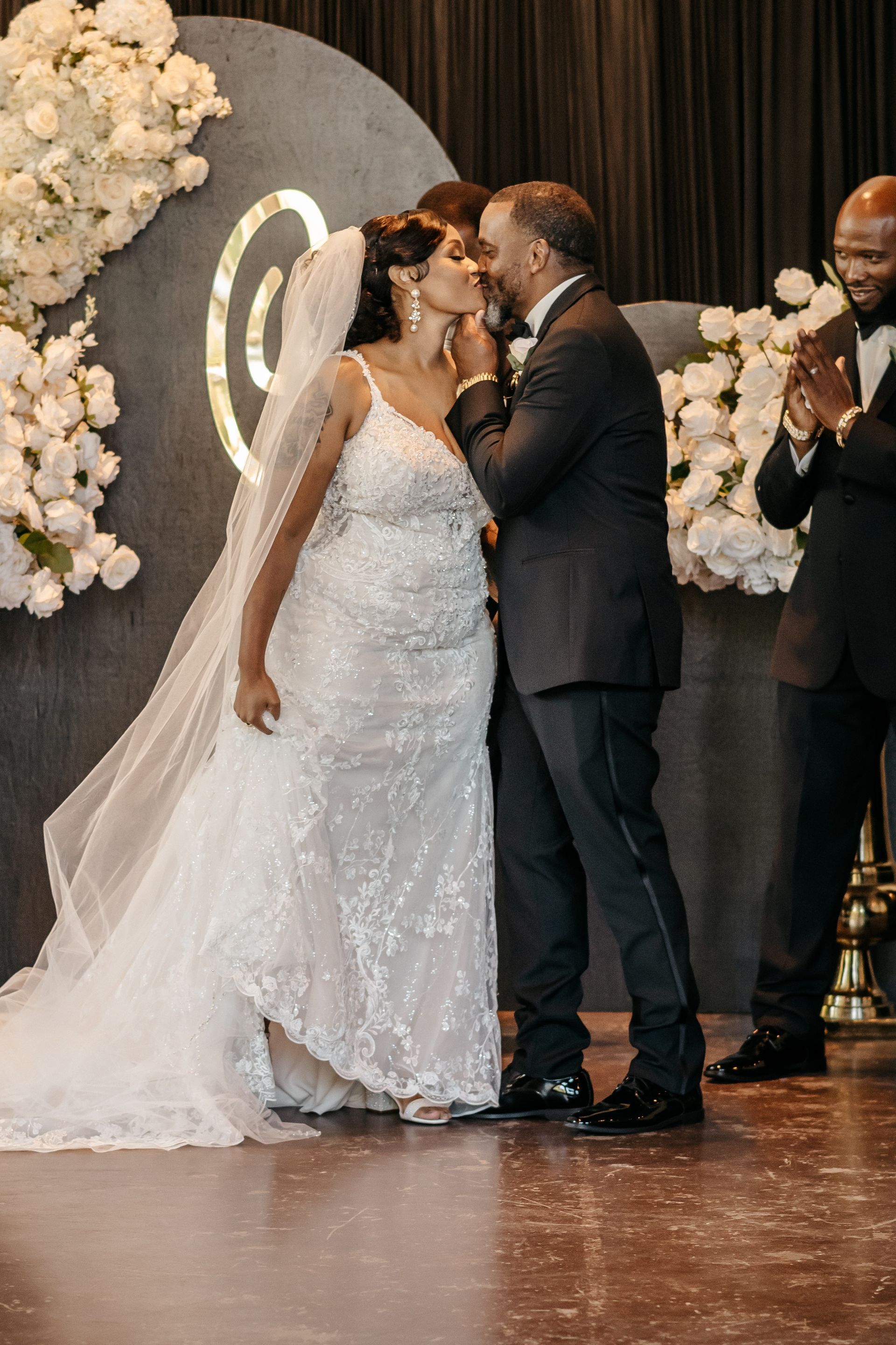 A bride and groom kissing at their wedding ceremony.
