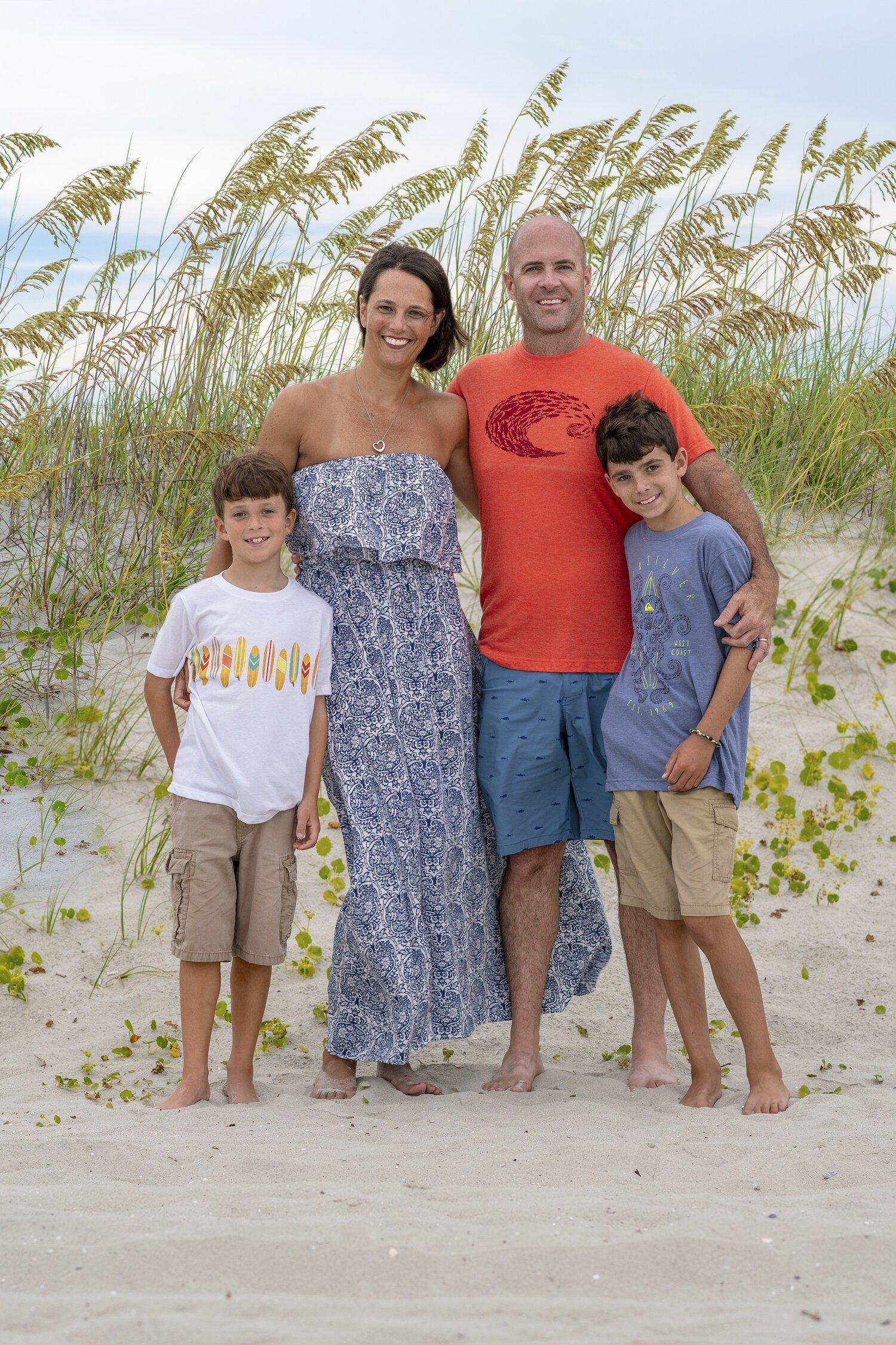 A family is posing for a picture on the beach.