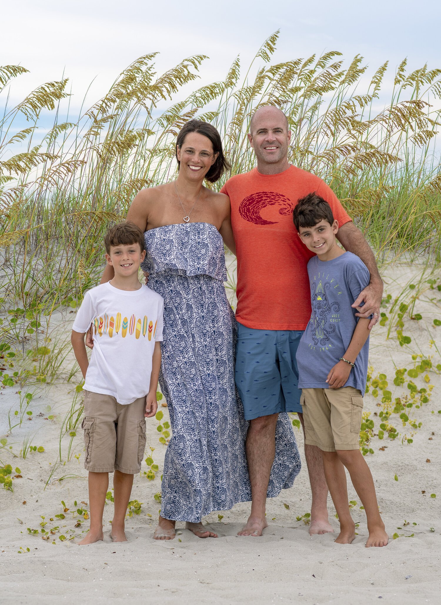 A family is posing for a picture on the beach.