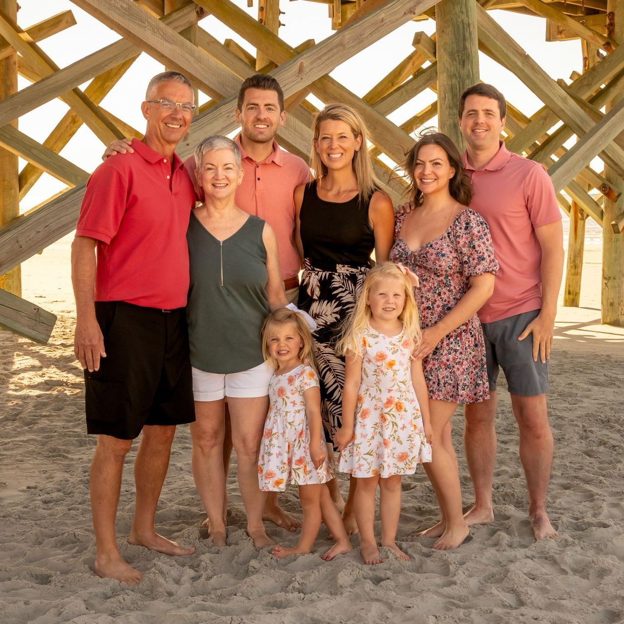 A group of people are posing for a picture on the beach.