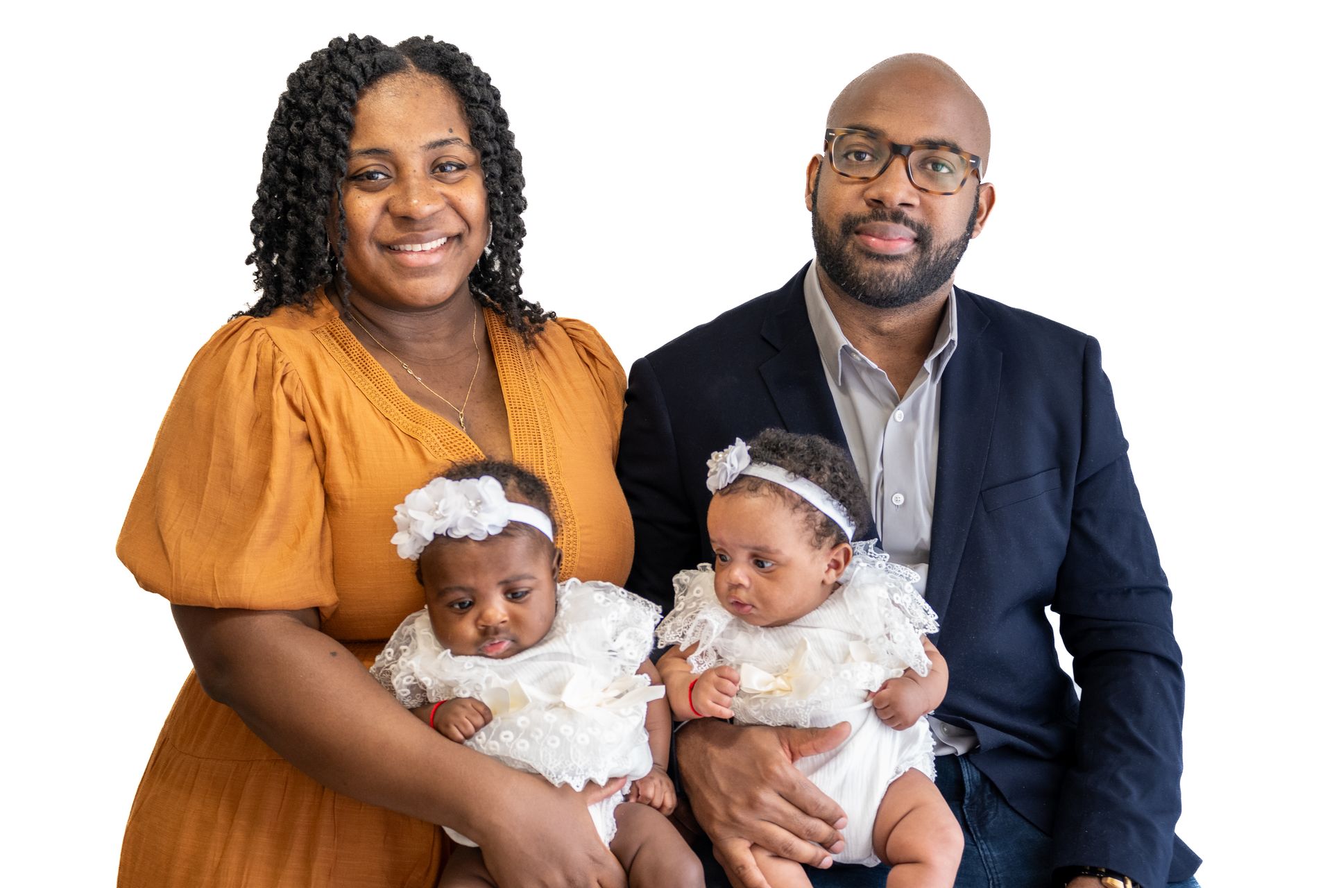 A man and a woman are holding two babies and posing for a picture.