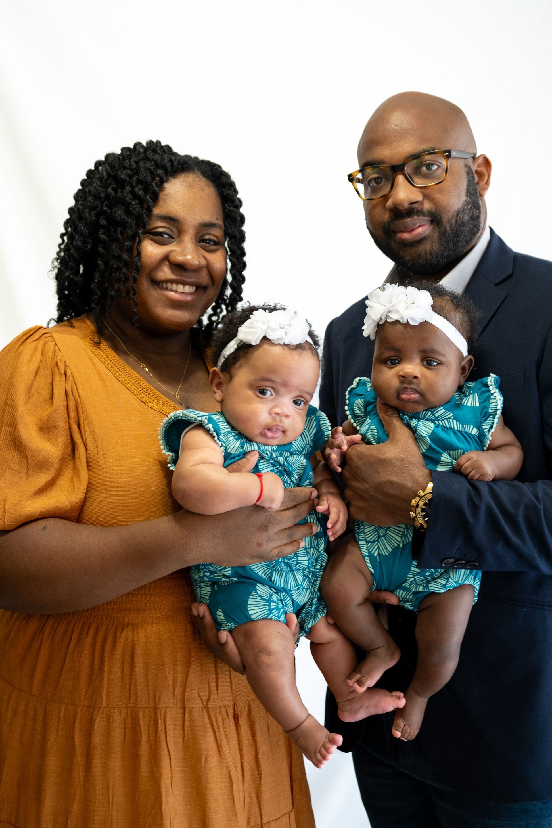 A man and woman are holding two babies in their arms.