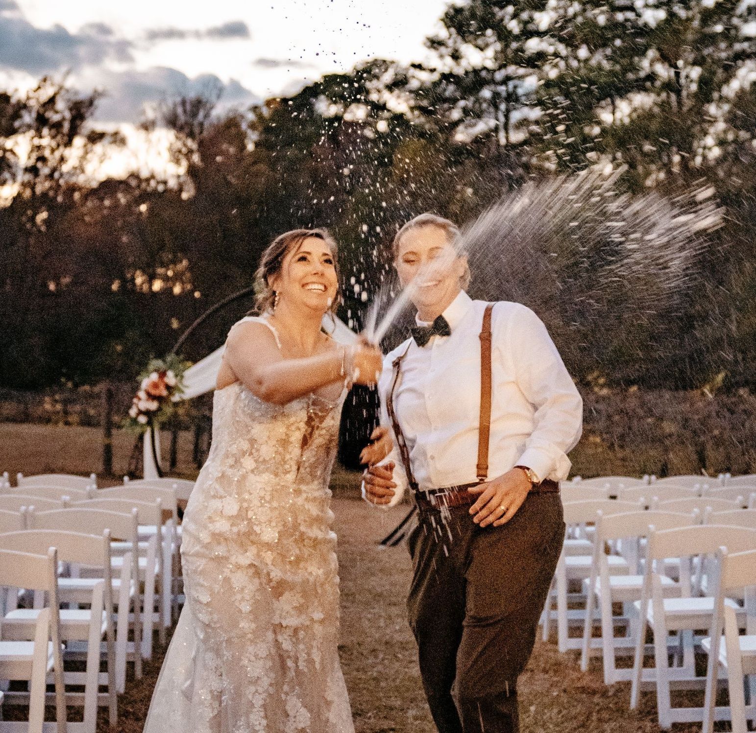 A bride and groom are celebrating their wedding with champagne.
