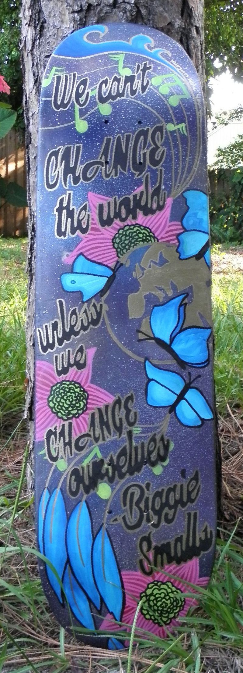 A skateboard with a painting of butterflies on it