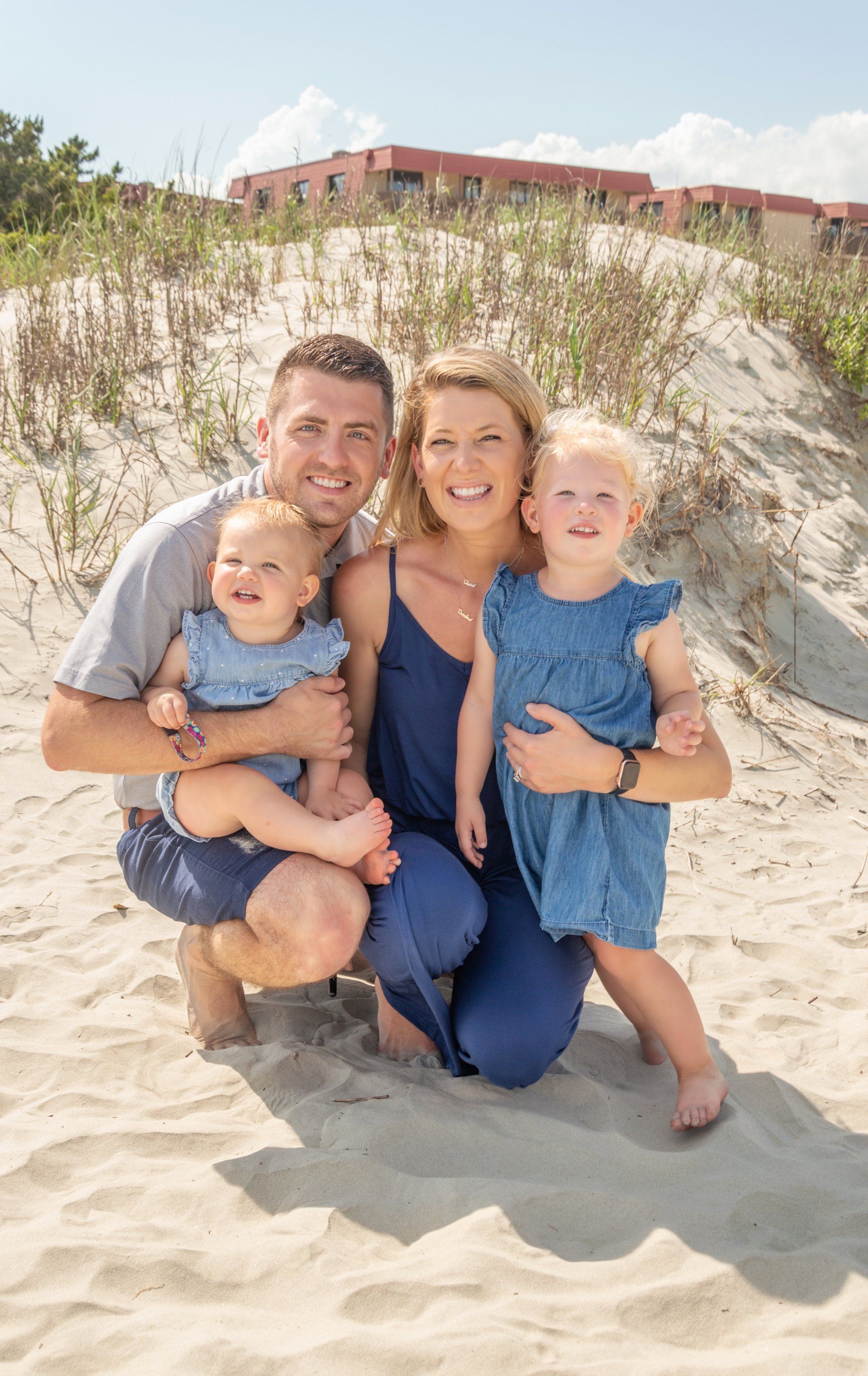 A family is posing for a picture on the beach.