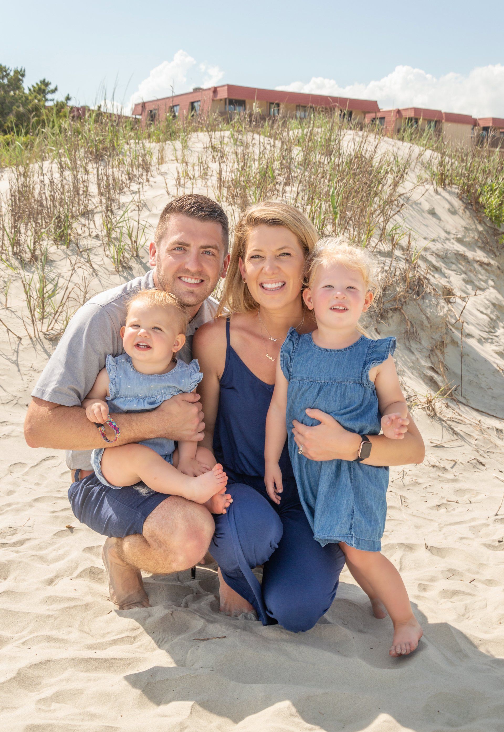 A family is posing for a picture on the beach.