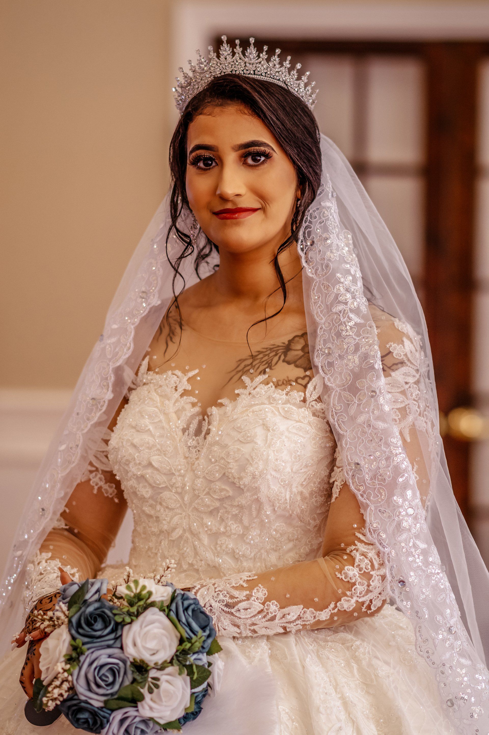 The bride is wearing a tiara and holding a bouquet of flowers.