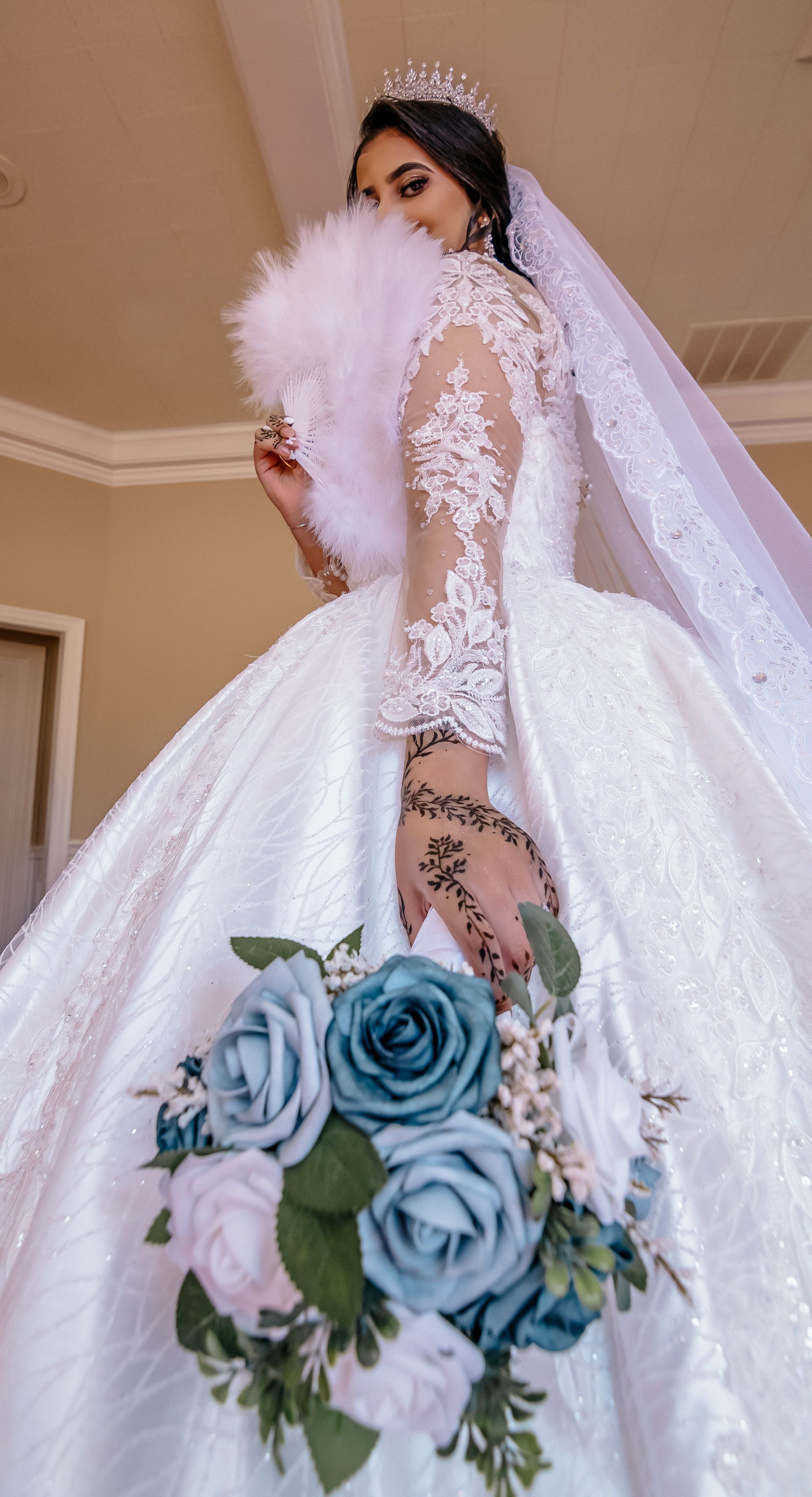 A bride in a wedding dress is holding a bouquet of blue roses.