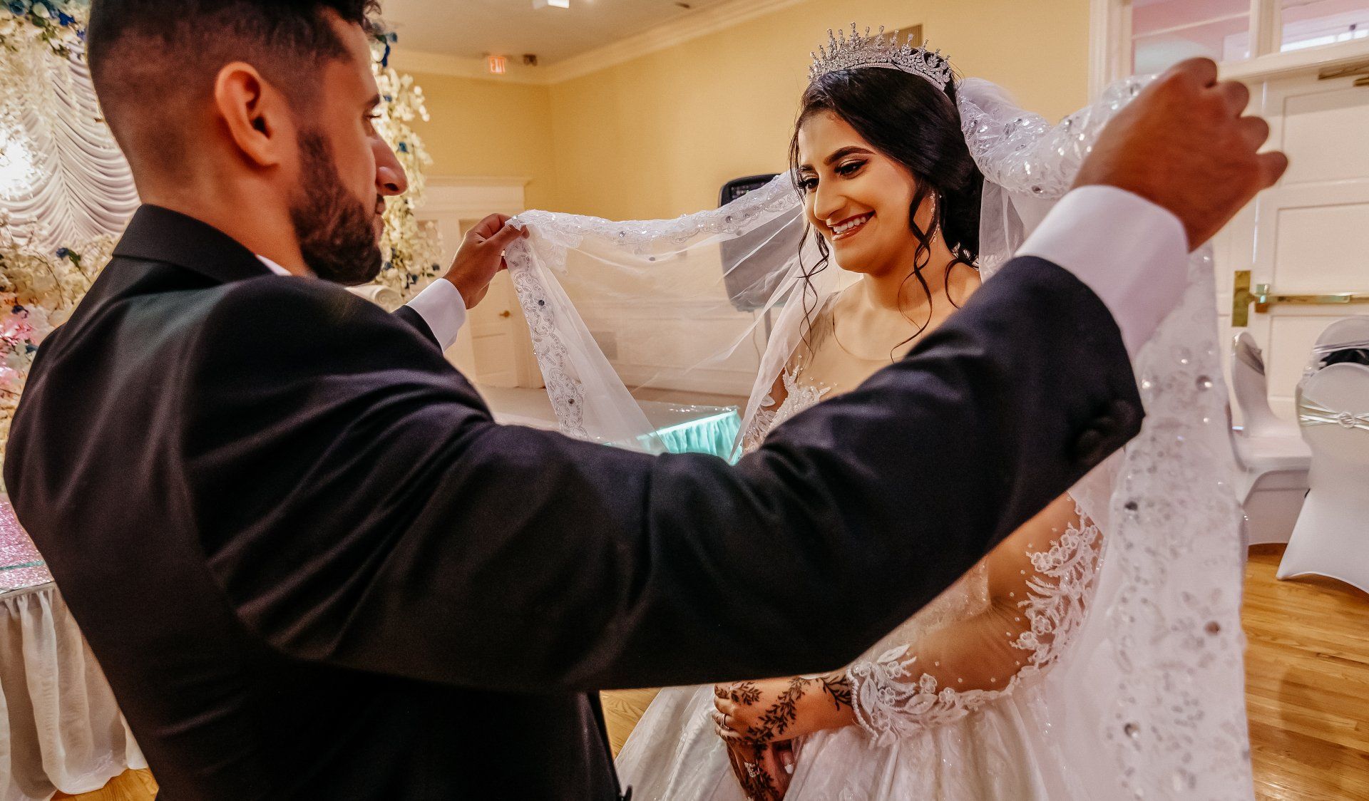 A bride and groom are posing for a picture at their wedding reception.