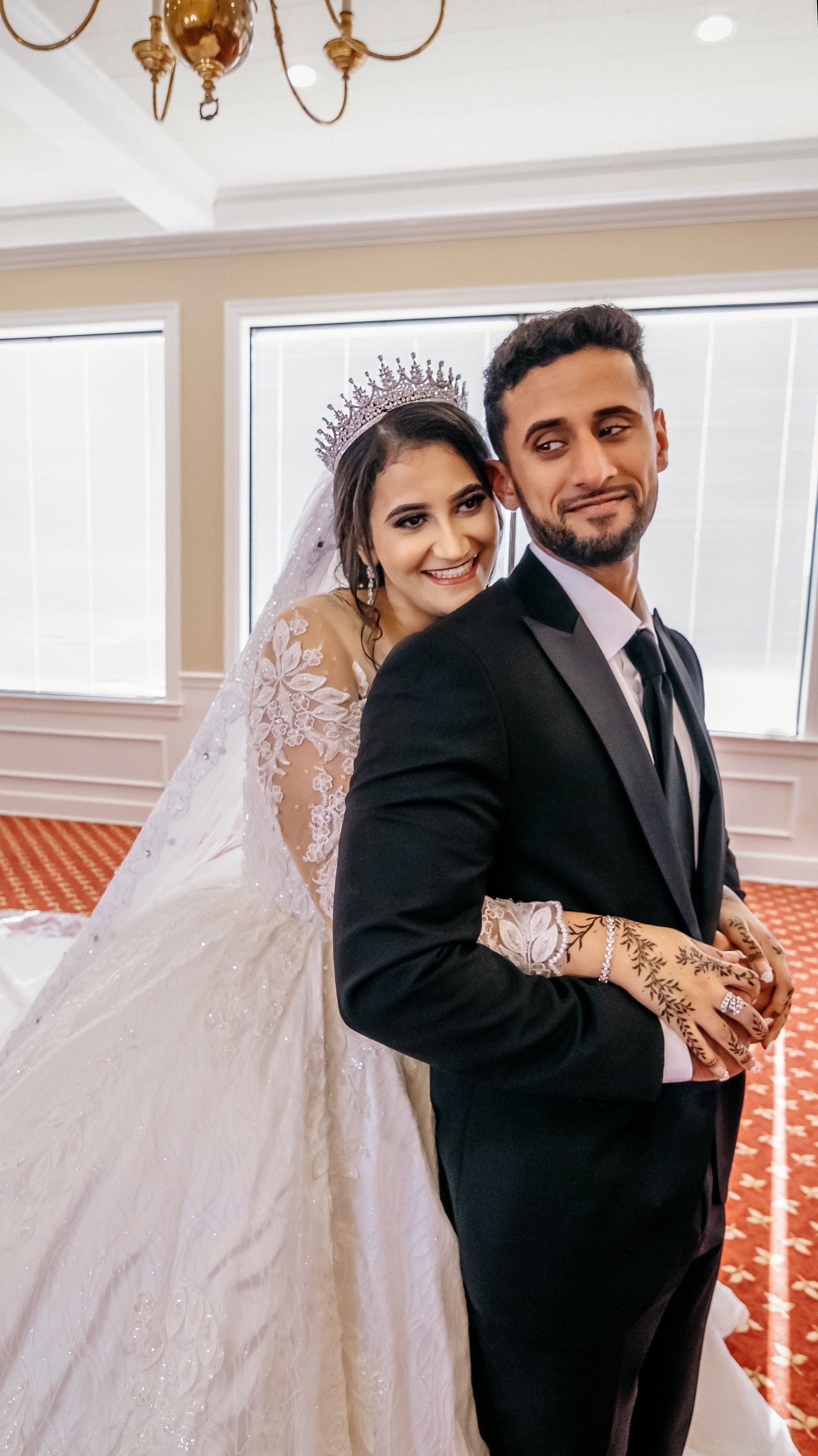 A bride and groom are posing for a picture at their wedding.