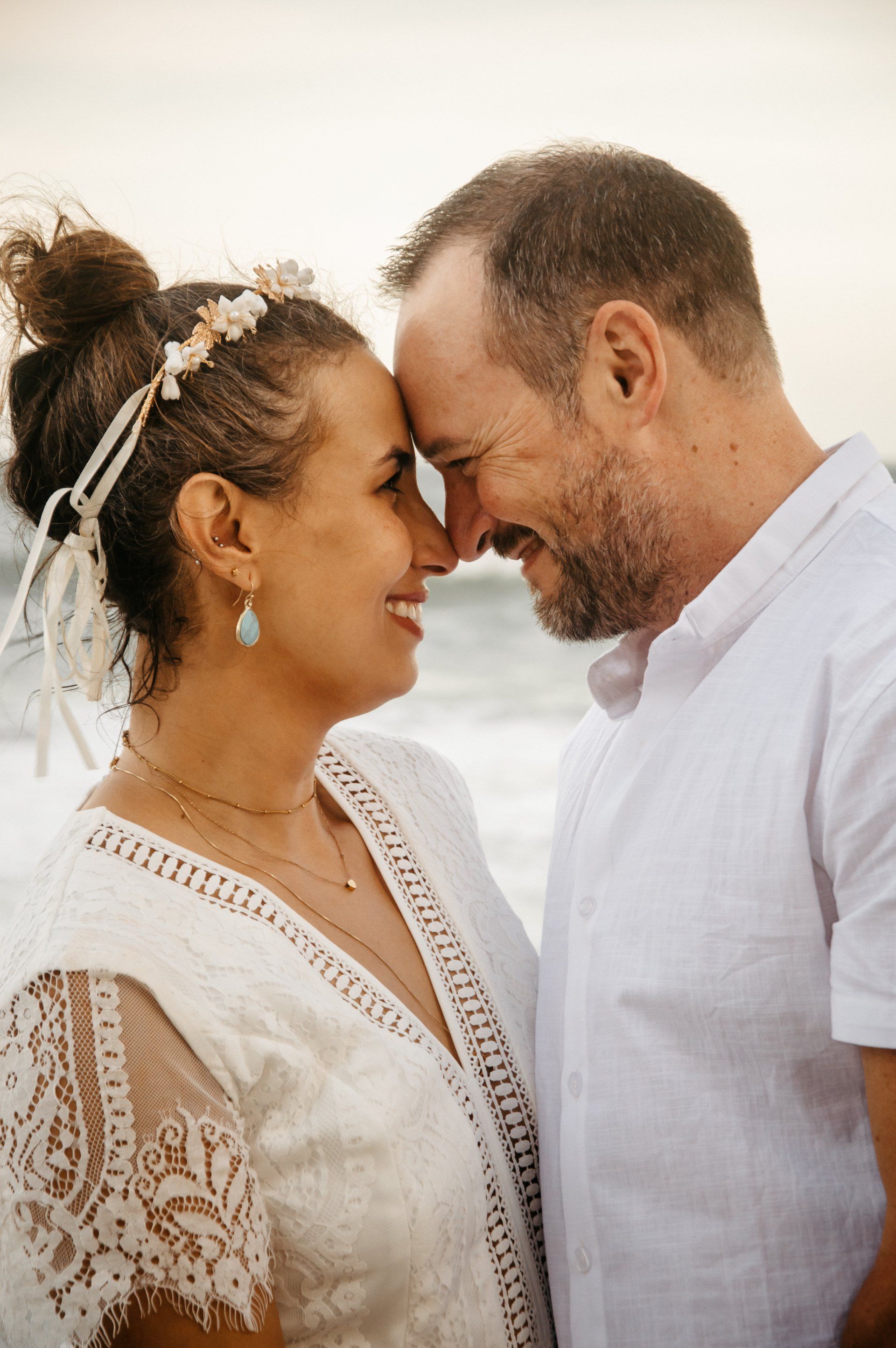 A man and a woman are looking at each other on the beach.