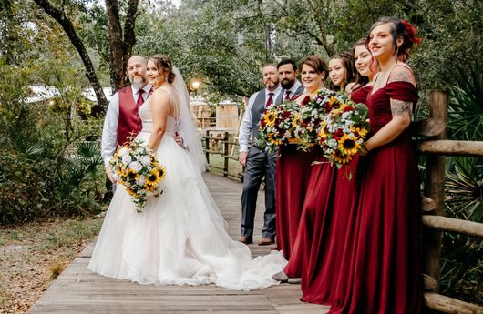 A bride and groom are posing for a picture with their wedding party.
