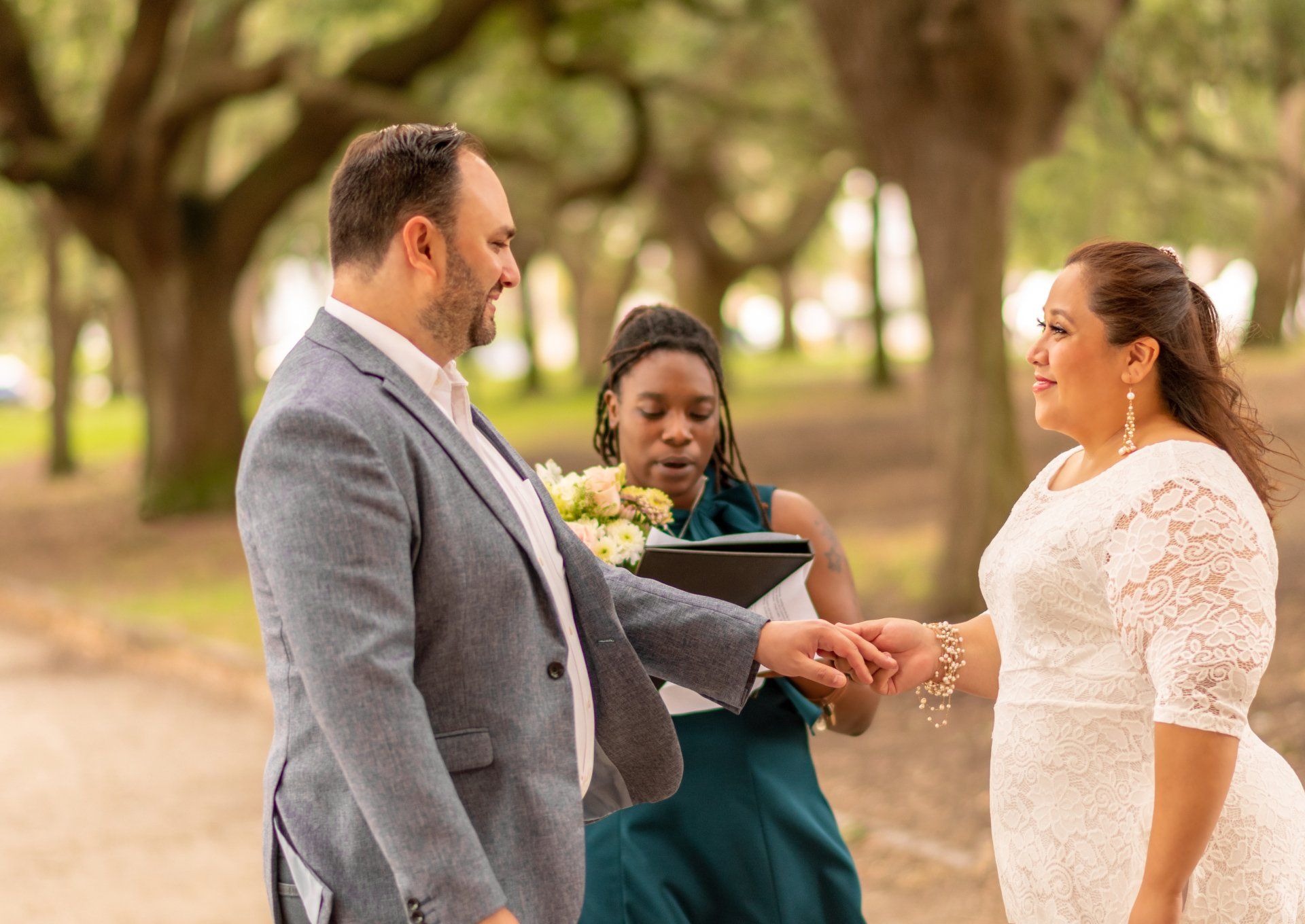 A man is putting a wedding ring on a woman 's finger.