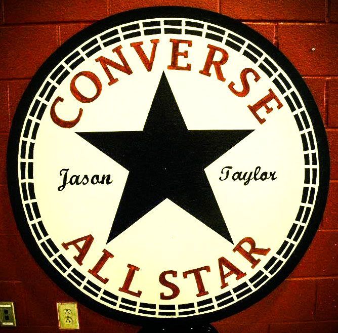 A converse all star logo on a red brick wall
