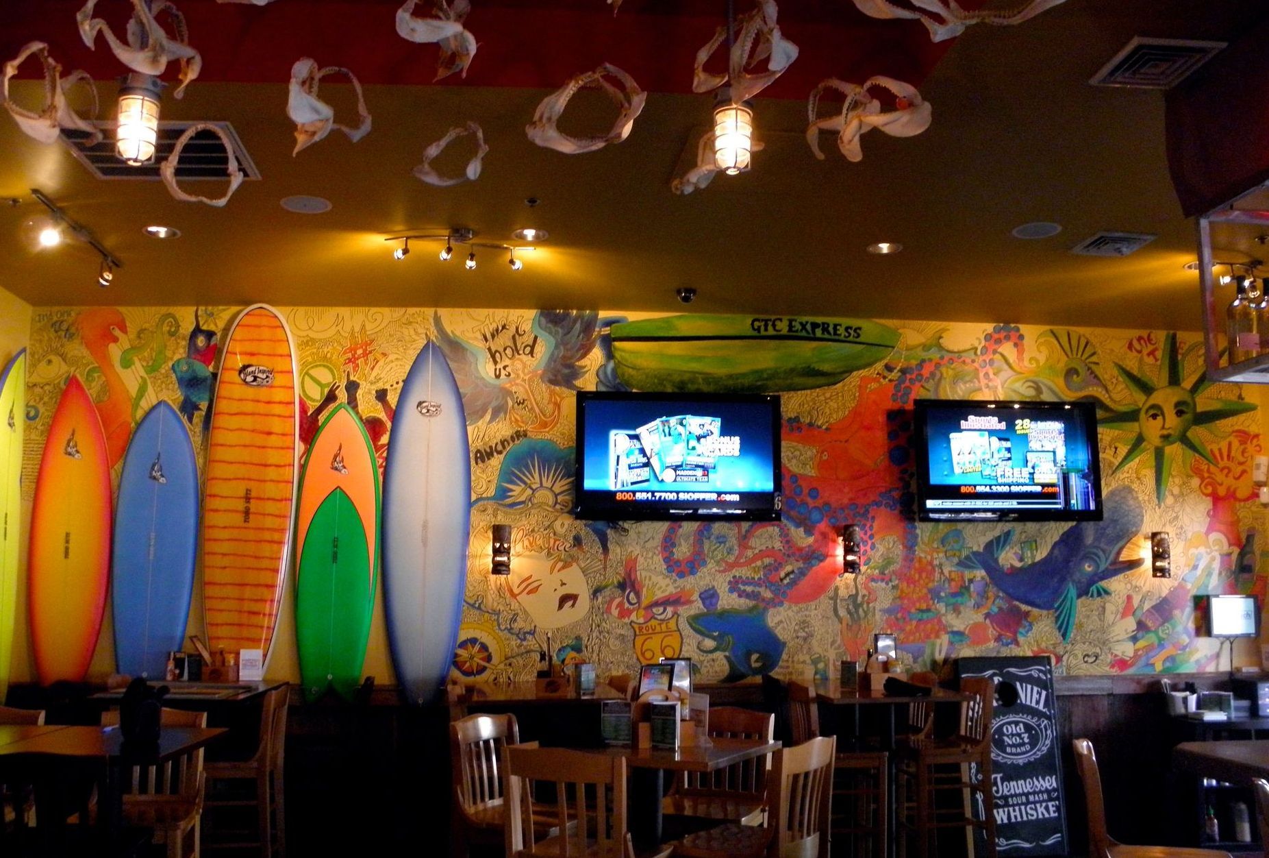 A restaurant with a mural of surfboards on the wall