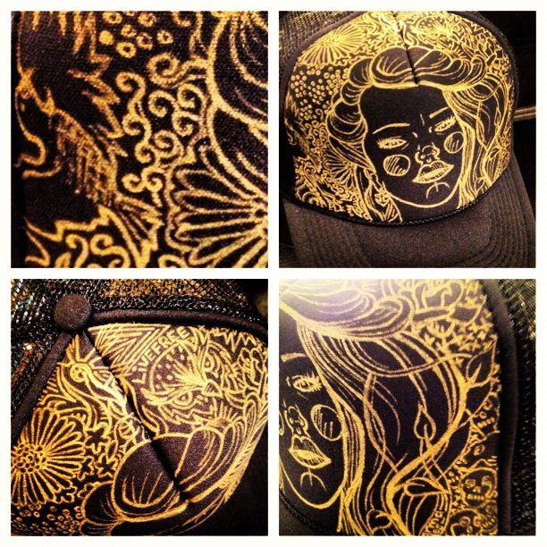 A black and gold hat with a woman 's face on it