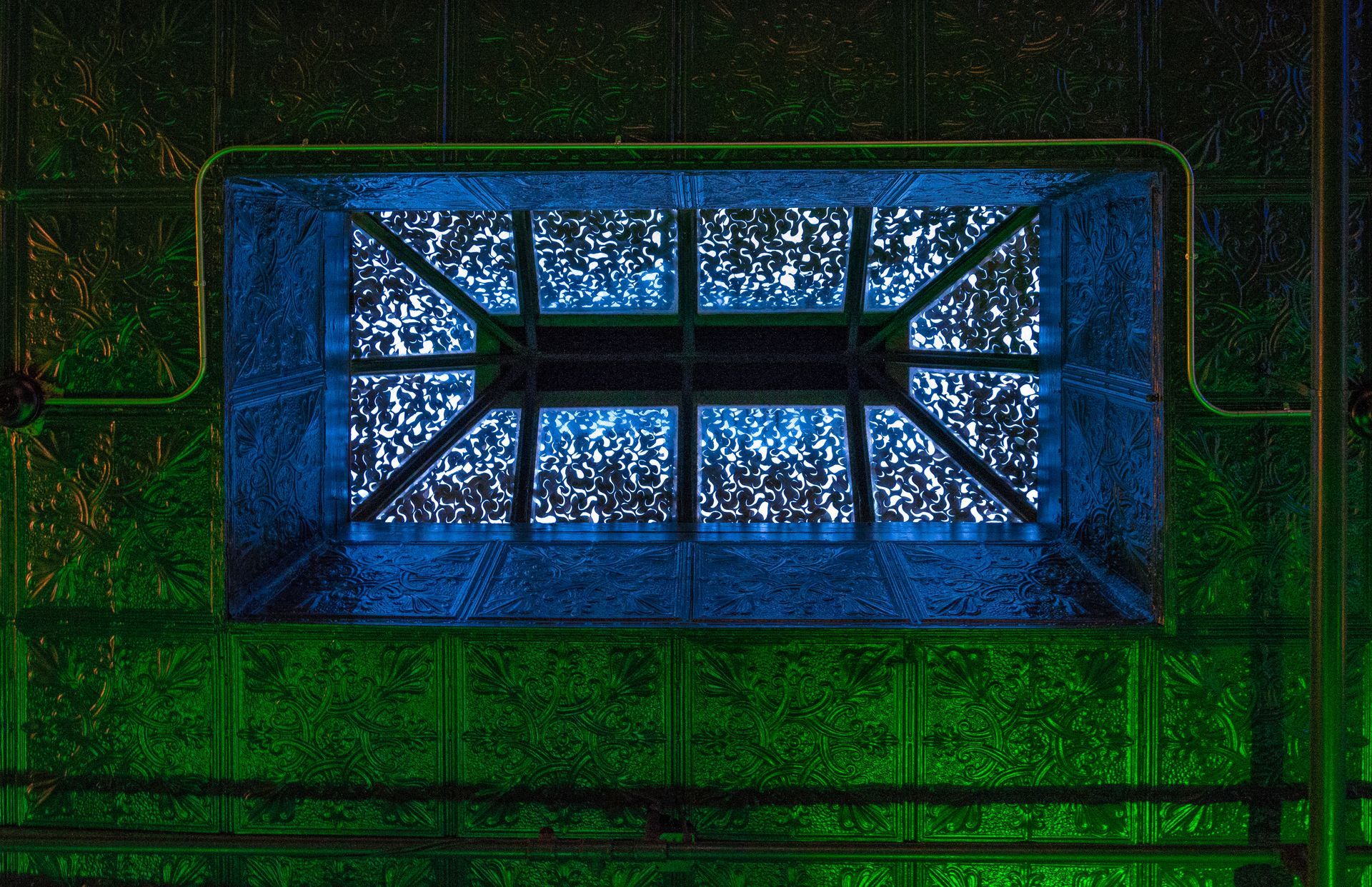 A blue and green stained glass window on a building