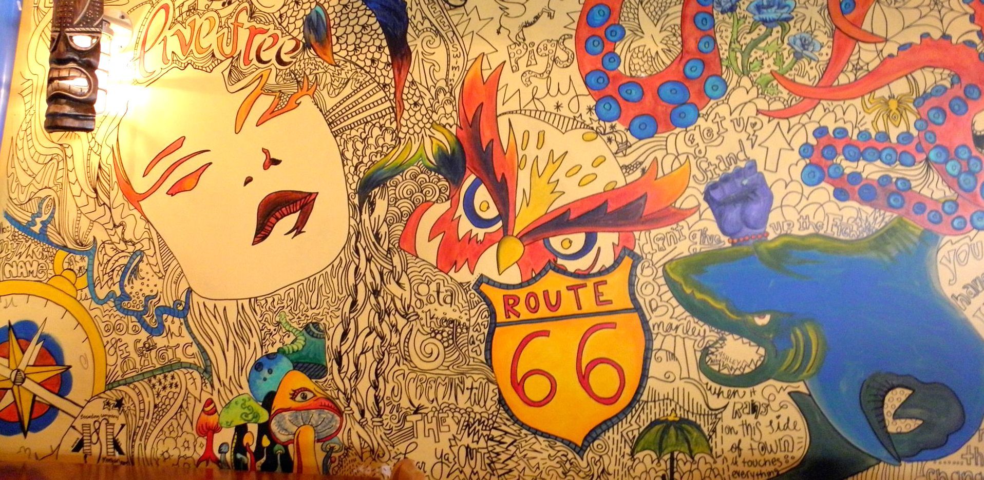 A wall with a painting of a woman and a route 66 sign